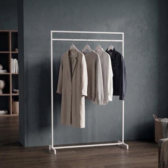 Minimalistisk klädställning med neutrala plagg mot mörk vägg