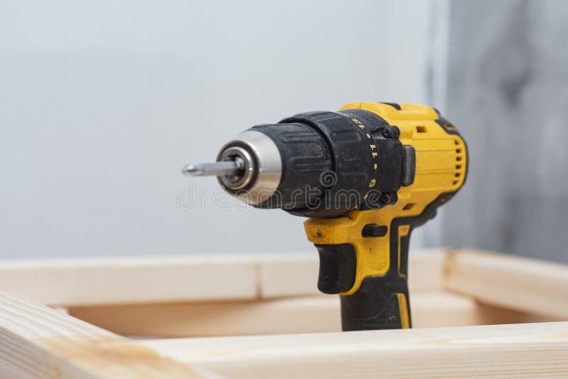 Närbild av en begagnad gul och svart skruvdragare på en byggarbetsplats.