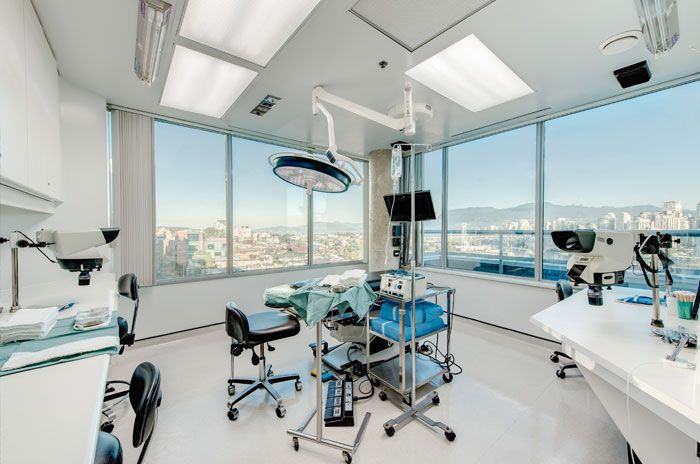 Modern operationssal för hårtransplantation med utsikt över staden.